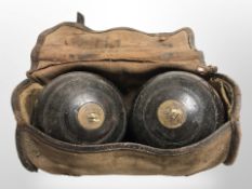 A pair of 19th-century turned wooden lawn bowls in canvas bag.