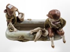 A Royal Dux figure of two children feeding birds, stamped 1665 to base, width 25cm.