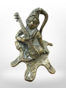 A 19th century Indian brass figure of a seated musician,