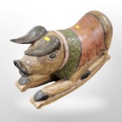 A carved and painted wooden rocking seat in the form of a pig,