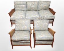 An early 20th-century mahogany-framed bergère three-piece lounge seat in floral upholstery,
