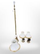 An ornate gilt metal and white marble standard lamp surmounted by three cherubs,