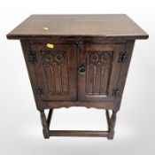 A reproduction carved oak double door low cabinet,