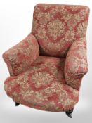 An early 20th century mahogany armchair in red floral fabric