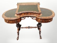 A Victorian rosewood kidney shaped writing table with green leather inset writing surface and brass