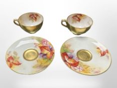 A pair of Royal Worcester porcelain teacups and saucers,