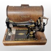 An antique hand sewing machine in oak box