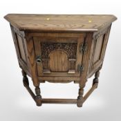 A reproduction carved oak side cabinet,