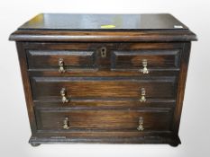 An oak fall front jewellery chest, in the form of a chest of four drawers,