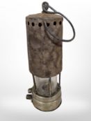 A 19th-century brass and steel miner's lamp.