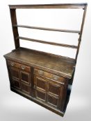 A George III oak dresser with plate rack above, 134cm wide x 47cm deep x 184cm high.