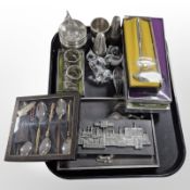 A group of boxed stainless steel and pewter cutlery, further pewter table wares, relief plaques,