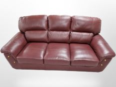 A contemporary Burgundy leather three seater settee,