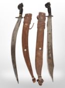 Two horn-handled curved swords in leather sheathes, one with blade marked 