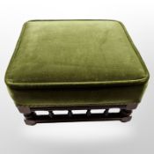 A square footstool in green dralon