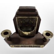 An oak candle stand with brass plaque marked 