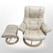 A cream leather swivel armchair and matching stool