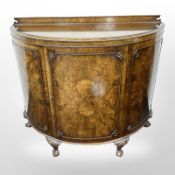 A burr walnut demi-lune side cabinet on claw and ball feet,