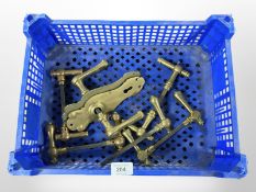 A crate of vintage brass door handles and plates