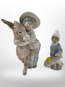 A Lladró figure of a boy with a donkey, and a further figure of a girl with a lamb.