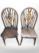 A pair of wheel back dining chairs