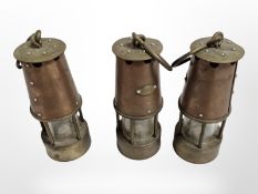 Three small copper and brass miner's lamps, height 12cm.