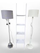A contemporary four tier shelf and two standard lamps