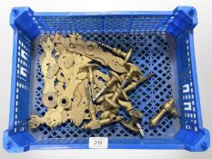 A crate of vintage brass door handles and plates