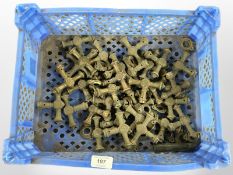 A crate of vintage brass 'T' shaped door handles