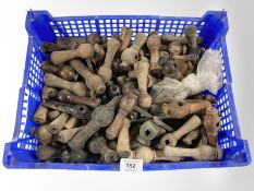 A crate of antique turned wooden door handles.