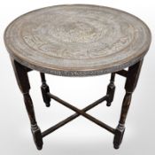 A Middle Eastern circular occasional table, with brass top,