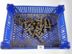 A crate of 'T'-shaped brass door handles