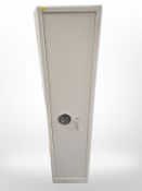 A steel gun cabinet with slots for five guns plus ammunition box above, with two keys,