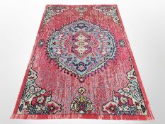 A contemporary machine-made rug on red ground, 235cm x 160cm.