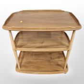 An Ercol elm and beech three tier trolley on castors,
