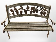 A weathered teak and cast iron garden bench,