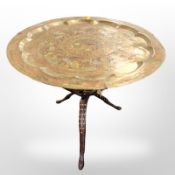 An Indian hardwood and bone inlaid tripod occasional table with enameled Benares brass top,