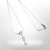 An 18ct white gold three stone diamond necklace, approximately 0.