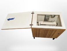 A Husqvarna electric sewing machine in teak effect cabinet