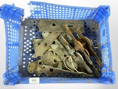 A crate of vintage brass door plates and fixings