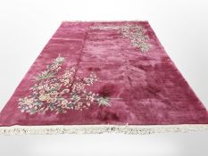 A large Chinese woolen carpet on plum ground, 394cm x 275cm.