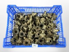 A crate of vintage brass door handle collars