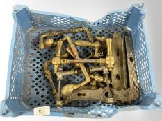 A crate of vintage brass door handles and plates