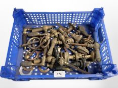A crate of vintage brass door handles and parts