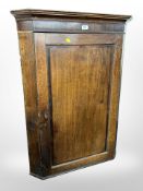 A George III oak hanging corner cabinet,