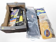 A group of hold-alls, tool belts and other work wear, all in retail packaging.