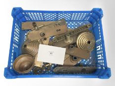 A crate of vintage brass door plates and a brass sign.