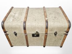 An early 20th century canvas & wooden bound trunk,