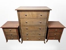 A contemporary five drawer chest and pair of matching bedside cabinets
