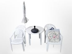 A plastic garden patio table, four stacking chair,